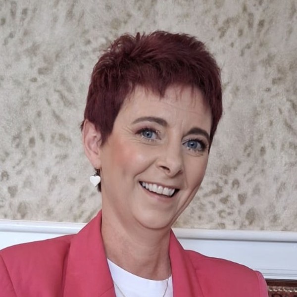 Deirdre Treanor smiling in a pink blazer